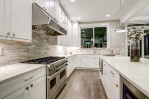 Modern kitchen with white countertops and cabinets and stainless steel stove